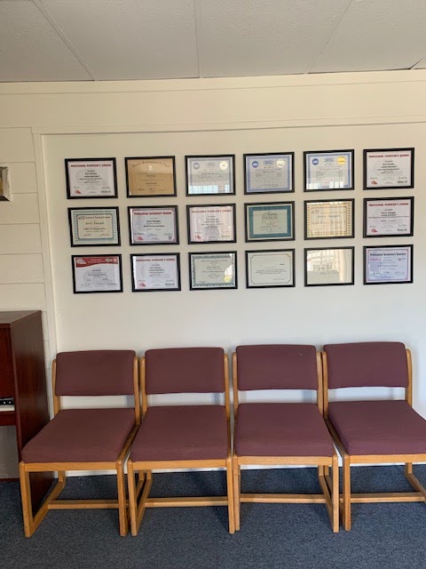 Waiting-area chairs under a wall of framed certificates